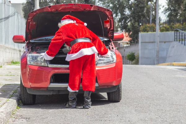 Święty Mikołaj Sprawdza Silnik Samochodu Przed Jego Samochodem Który Jest — Zdjęcie stockowe