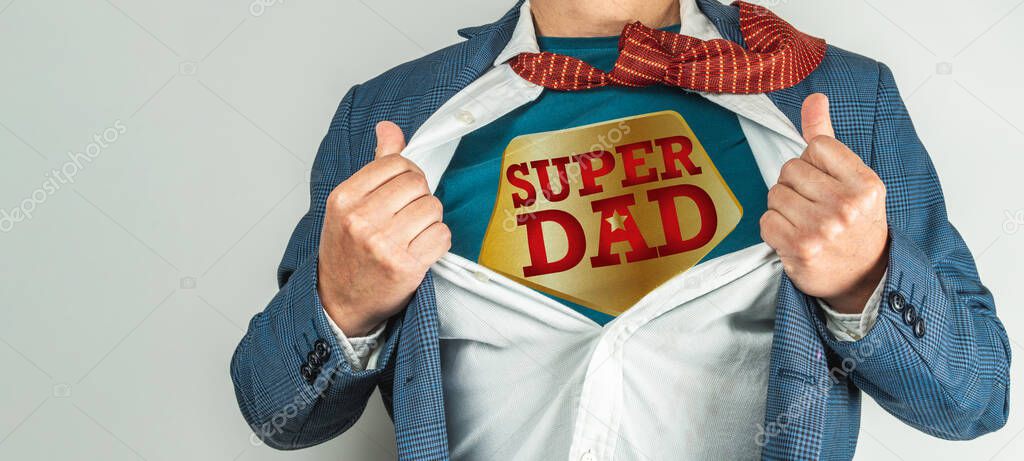 Man in a suit who opens his white shirt and tie to become a super hero, super dad. Father's day concept
