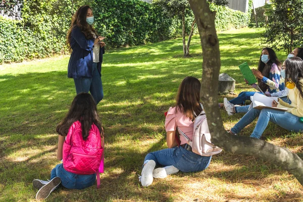 Açık hava öğretmenleri ve Latin genç öğrenciler Coronavirus önleme maskeleriyle kendilerini koruyorlar.
