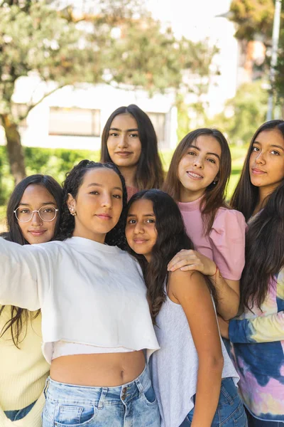 Bir grup genç arkadaş dışarıda selfie çekiyorlar.