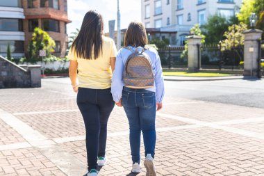 Anne ve kızının arka arkaya okula doğru yürürken çekilmiş fotoğrafları.