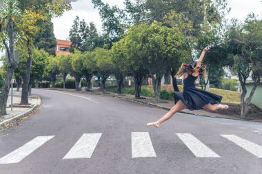 Yaya geçidinde sokakta akrobatik dönüş yapan bir balerin.