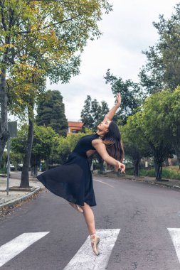 Yaya geçidinde sokakta dans eden bir balerinin dikey pozu.