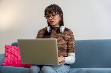 Uzaktan öğrenme zevkini evinin rahatlığında yaşayan genç bir kadın.