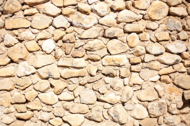 parlak güneş ışığında rustik taş duvar dokusu