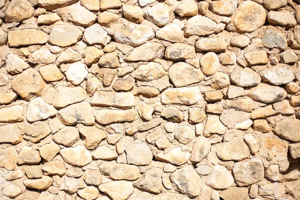 明るい日差しの中で素朴な石垣の質感 — ストック写真