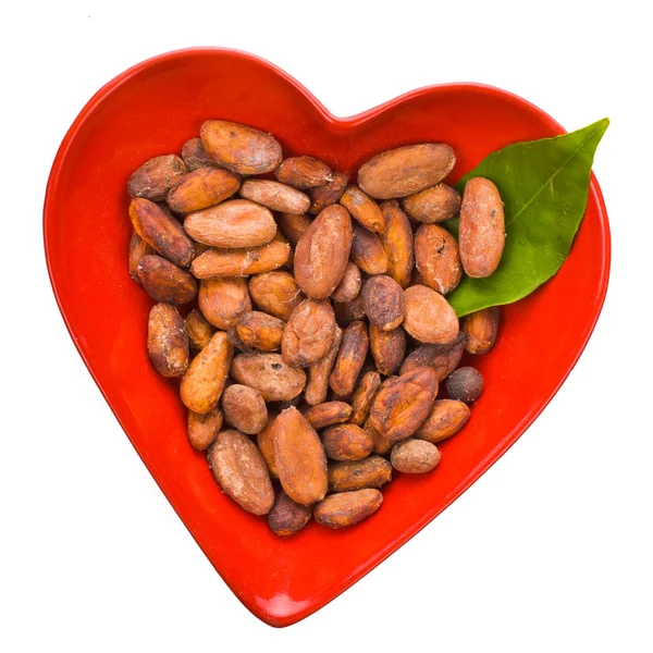 Cacao beans in a heart shape bowl — Stock Photo, Image