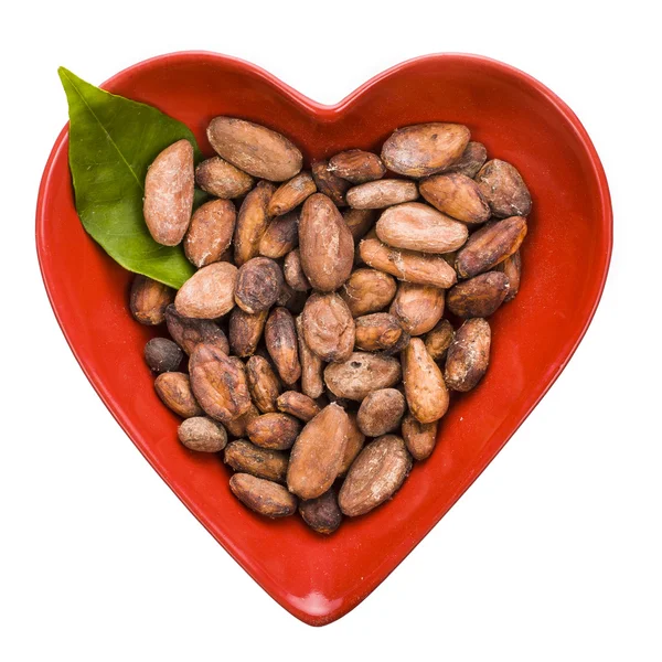 Cacao beans in a heart shape bowl — Stock Photo, Image