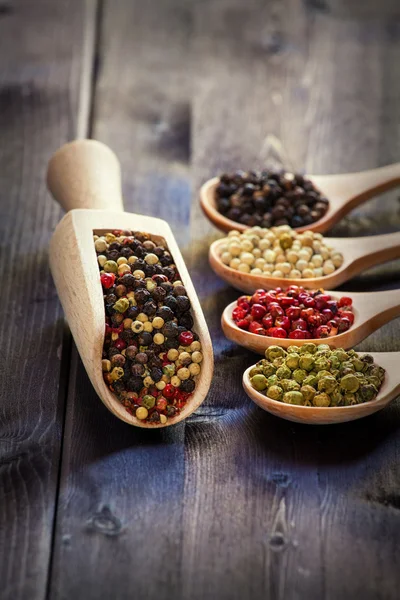 Mixed peppercorns in a wooden spoon — Stock Photo, Image