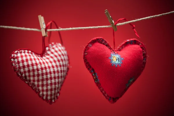 Kolorowe tkaniny serca na czerwonym tle — Zdjęcie stockowe