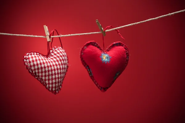 Colorful fabric hearts on red backgrounds — Stock Photo, Image