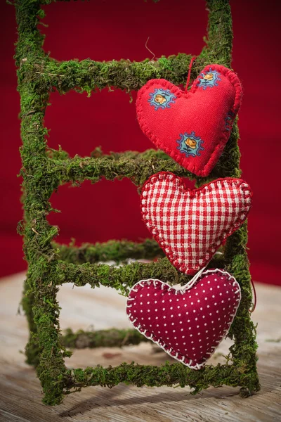 Colorful fabric hearts on red backgrounds — Stock Photo, Image