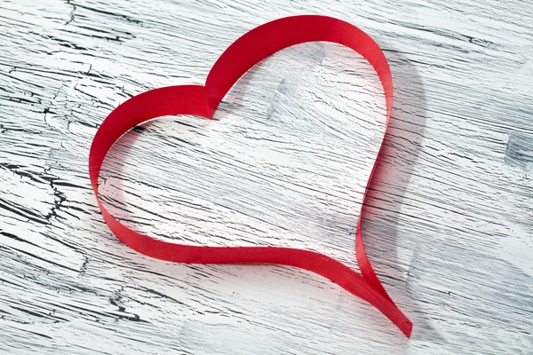 Red ribbon heart on wooden background — Stock Photo, Image