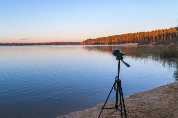ポータブルレコーダーは湖畔の三脚に立っています 自然の音を録音する ストック画像