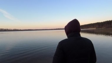 Sabahleyin adam gölün kıyısında duruyor. Doğa kavramıyla birlik