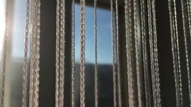 Güneşli bir günde dekoratif iplik perdeleri, kapat. İp perde arkaplanı. Odanın içi.