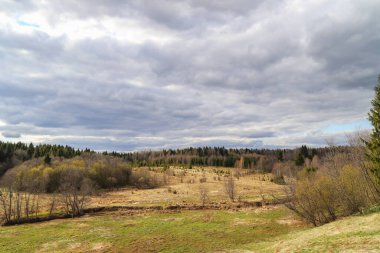 Bahar manzarası. Bulutlu bir günde tarlalar, nehir ve ormanlar. Tepeden bak. Güzel doğa arkaplanı