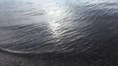 Nehir yüzeyine yağmur damlaları düşer. Çakıl taşlı kumlu bir taban suyun içinden görülebilir. Doğa arkaplanı 
