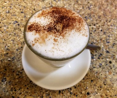 Tarçın ve kakao serpilmiş köpüklü Cappuccino Kahve fincanı manzarası.