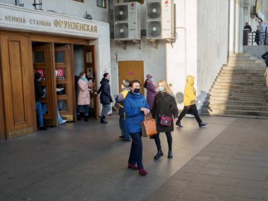 Moskova. - Rusya. 28 Ekim 2020. Maskeli yolcular Moskova metro istasyonundan eski ahşap kapılardan çıkıyorlar. Toplu taşımada tıbbi maske takmak zorunludur..