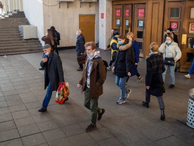 Moskova. - Rusya. 28 Ekim 2020. Maskeli yolcular Moskova metro istasyonundan eski ahşap kapılardan çıkıyorlar. Toplu taşımada tıbbi maske takmak zorunludur..