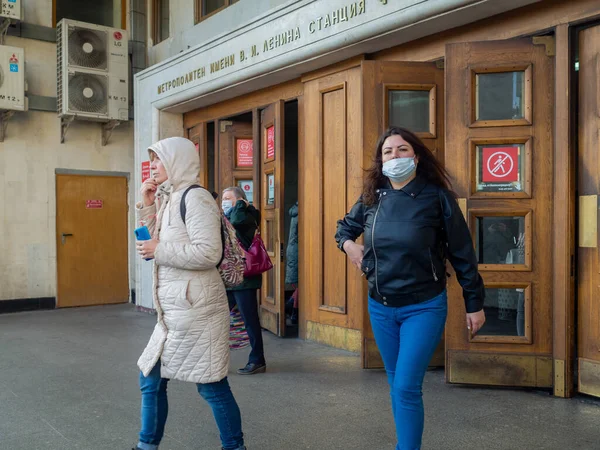 モスクワだ ロシアだ 2020年10月28日 仮面の乗客は古い木製のドアを通ってモスクワの地下鉄駅を出発します 公共交通機関における医療用マスクの着用義務 — ストック写真