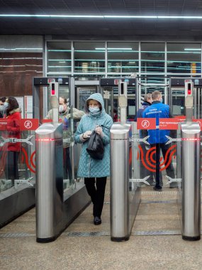 Moskova. - Rusya. 29 Ekim 2020. Yolcular Moskova metro istasyonundaki otomatik turnikelerden geçiyorlar. İnsanların yüzlerinde enfeksiyonlara karşı koruyucu maskeler ve viral enfeksiyonların yayılması