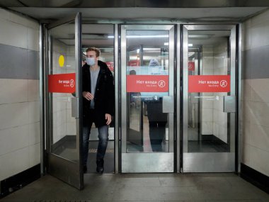 Moskova. - Rusya. 26 Ekim 2020. Yüz maskesi takan yolcular Moskova metro istasyonunu cam kapılardan terk ediyor. Toplu taşımada tıbbi maske takmak zorunludur..
