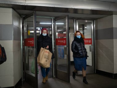 Moskova. - Rusya. 26 Ekim 2020. Yüz maskesi takan yolcular Moskova metro istasyonunu cam kapılardan terk ediyor. Toplu taşımada tıbbi maske takmak zorunludur..