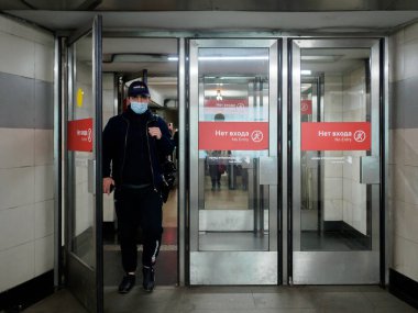 Moskova. - Rusya. 26 Ekim 2020. Yüz maskesi takan yolcular Moskova metro istasyonunu cam kapılardan terk ediyor. Toplu taşımada tıbbi maske takmak zorunludur..
