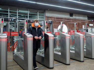 Moskova. - Rusya. 29 Ekim 2020. Yolcular Moskova metro istasyonundaki otomatik turnikelerden geçiyorlar. İnsanların yüzlerinde enfeksiyonlara karşı koruyucu maskeler ve viral enfeksiyonların yayılması