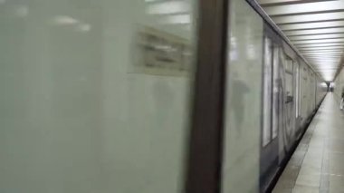 Tren metro istasyonu platformu boyunca hareket eder. Hareket bulanıklığı. Arabalar yüksek hızda titreşiyor. Şehrin yeraltı elektrik nakliyesi.