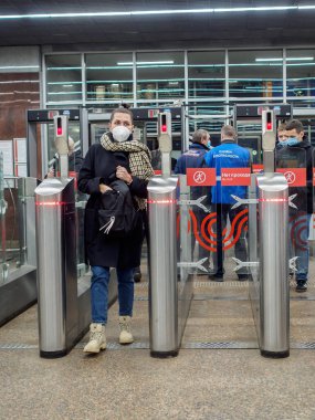 Moskova. - Rusya. 29 Ekim 2020. Yolcular Moskova metro istasyonundaki otomatik turnikelerden geçiyorlar. İnsanların yüzlerinde enfeksiyonlara karşı koruyucu maskeler ve viral enfeksiyonların yayılması