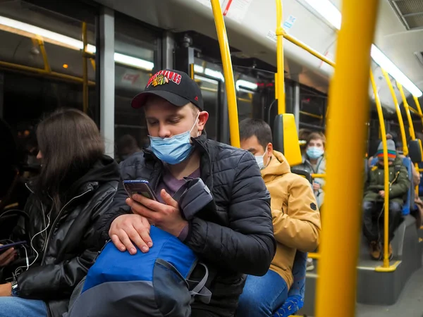 Молодой человек в городском автобусе внимательно смотрит на экран смартфона. — стоковое фото