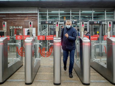Yolcular Moskova metro istasyonundaki otomatik turnikelerden geçiyorlar.. 