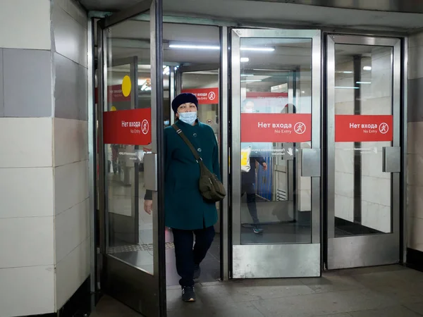 Moskwa. Rosja. 26 października 2020 Pasażerowie noszący maski twarzy opuszczają stację metra w Moskwie przez szklane drzwi. — Zdjęcie stockowe