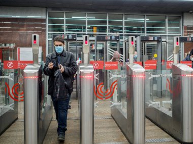 Yolcular Moskova metro istasyonundaki otomatik turnikelerden geçiyorlar.. 