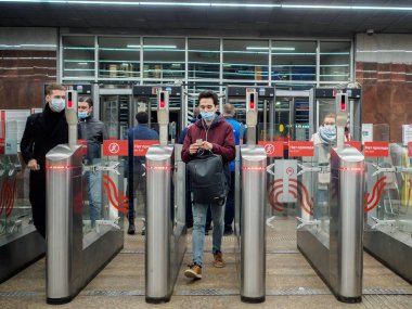 Yolcular Moskova metro istasyonundaki otomatik turnikelerden geçiyorlar.. 