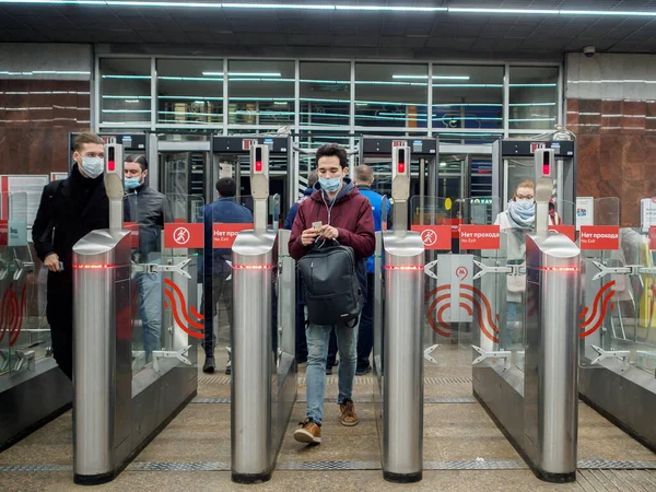 乗客はモスクワ地下鉄駅で自動ターンスタイルを通過します. — ストック写真