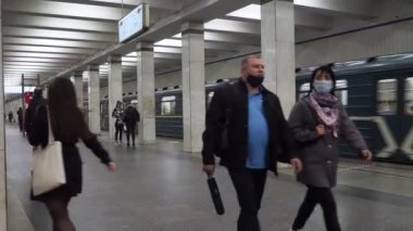 Metro istasyonunda maskeli yolcular.