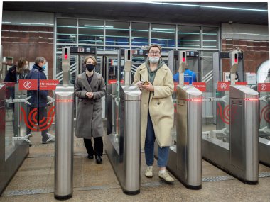 Yolcular Moskova metro istasyonundaki otomatik turnikelerden geçiyorlar.. 