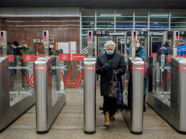 Yolcular Moskova metro istasyonundaki otomatik turnikelerden geçiyorlar.. 