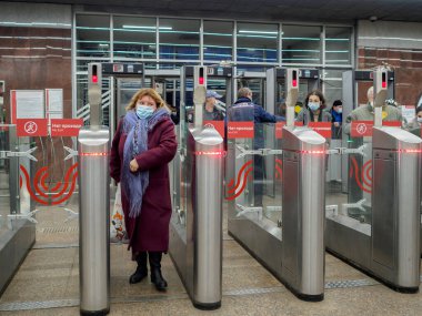 Yolcular Moskova metro istasyonundaki otomatik turnikelerden geçiyorlar.. 