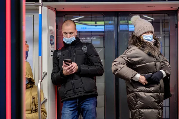 Un uomo in un vagone della metropolitana guarda il suo smartphone con entusiasmo. — Foto Stock