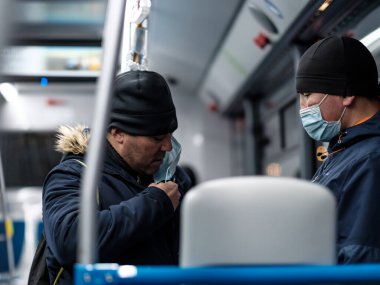 Şehir otobüsünde koruyucu bir maske takan bir adam..