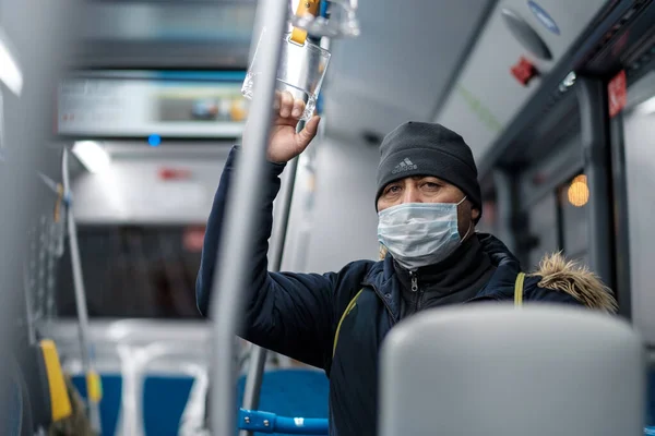 Человек в городском автобусе в защитной медицинской маске. — стоковое фото