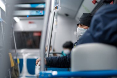 Şehir otobüsünde koruyucu bir maske takan bir adam..