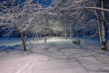 Şehir parkındaki ara sokakta fenerlerle aydınlatılan gece manzarası. 