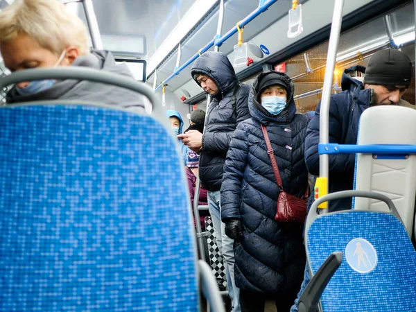 Женщина в медицинской маске стоит в автобусе. Пандемия коронавируса. — стоковое фото