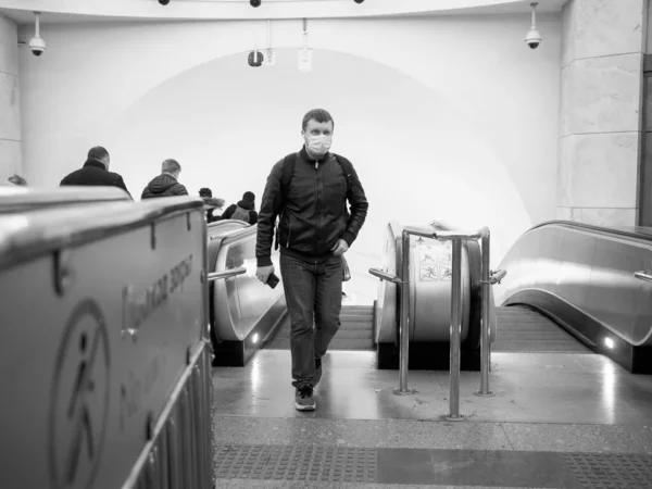 モスクワだ ロシアだ 2020年11月13日 地下鉄の乗客は地下からエスカレーターで移動します 人々の顔には ウイルス感染から医療用マスクを保護します 白黒写真 — ストック写真